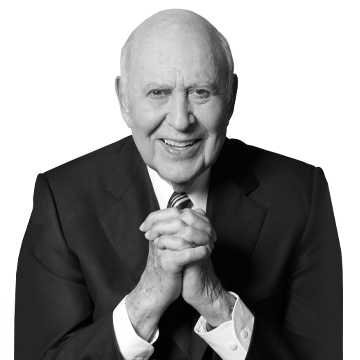 Carl Reiner sits with his hands folded in a black and white photo.